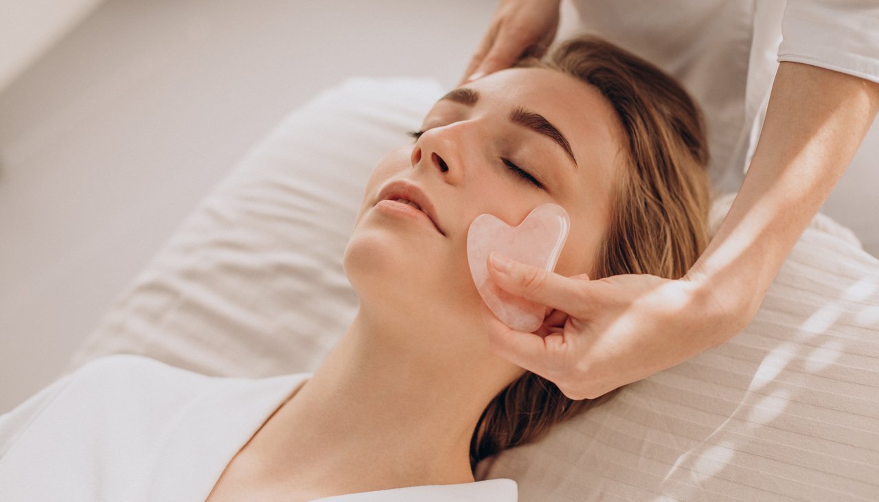 Woman in salon making beauty treatment with gua sha stone